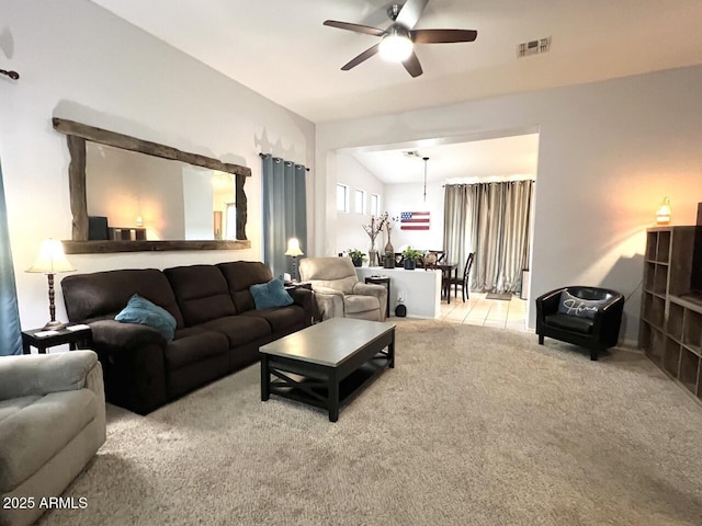 living room with ceiling fan, lofted ceiling, and light carpet