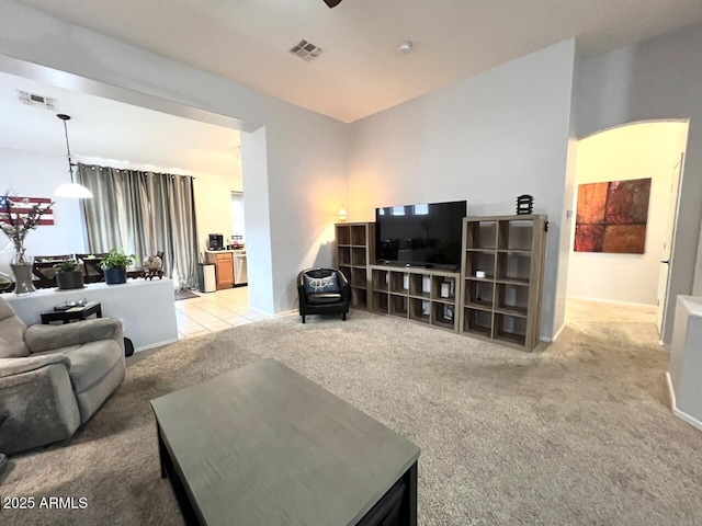 living area with light tile patterned floors, baseboards, visible vents, and light colored carpet