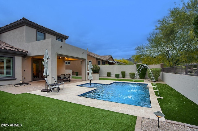 view of swimming pool with a yard, a patio, a fenced in pool, and a fenced backyard