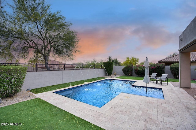 pool at dusk featuring a patio, a fenced backyard, a yard, and a fenced in pool
