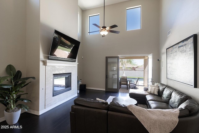 18515 N 97th Way, Scottsdale, AZ 85255 - living area with dark wood-style floors, a ceiling fan, baseboards, a towering ceiling, and a fireplace