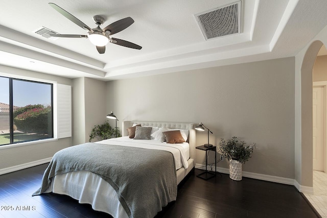 18515 N 97th Way, Scottsdale, AZ 85255 - bedroom with a raised ceiling, arched walkways, hardwood / wood-style floors, baseboards, and a ceiling fan