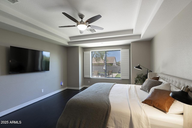 18515 N 97th Way, Scottsdale, AZ 85255 - bedroom featuring a tray ceiling, dark wood-style flooring, baseboards, and a ceiling fan
