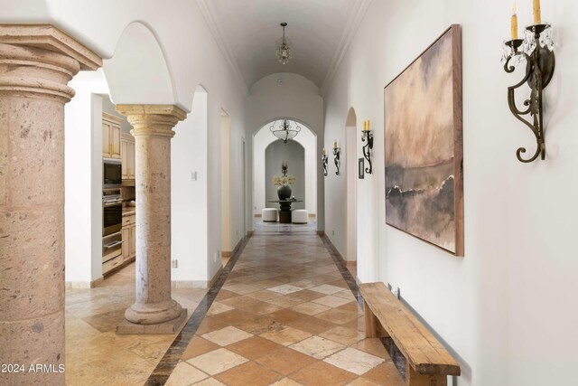 hallway with ornamental molding and ornate columns