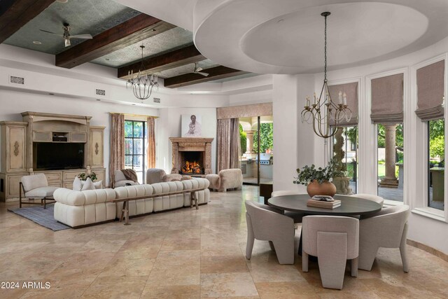 interior space with ceiling fan with notable chandelier, a raised ceiling, and beamed ceiling