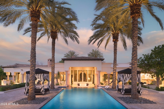 pool at dusk with a patio