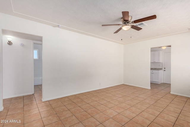 tiled empty room featuring a textured ceiling and ceiling fan