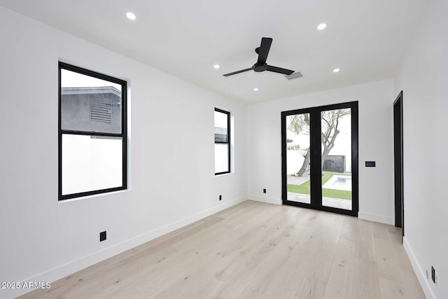 unfurnished room with light wood-type flooring, visible vents, baseboards, and recessed lighting