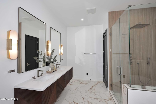 full bath featuring marble finish floor, a sink, a shower stall, and double vanity