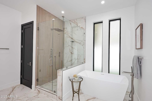 full bathroom featuring marble finish floor, a freestanding tub, a marble finish shower, and recessed lighting