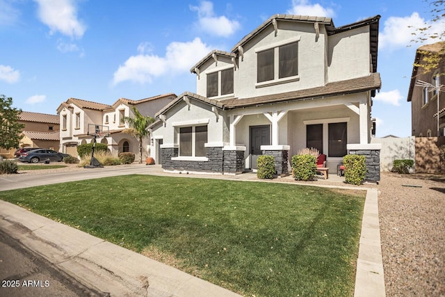 view of front facade featuring a front yard, stone siding, a tile roof, and stucco siding