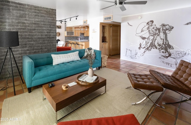 living room with track lighting, ceiling fan, and tile patterned flooring