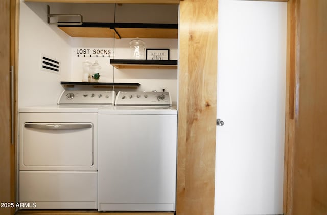 clothes washing area with separate washer and dryer