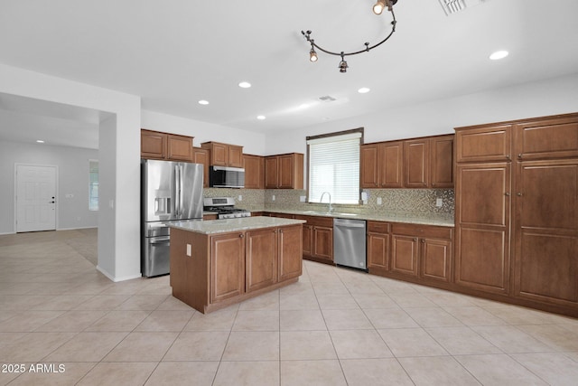8710 N 182nd Ave, Waddell, AZ 85355 - kitchen with a kitchen island, stainless steel appliances, brown cabinets, and tasteful backsplash