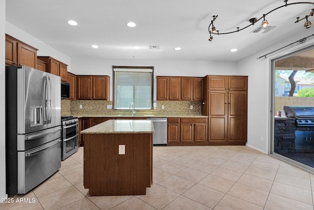 8710 N 182nd Ave, Waddell, AZ 85355 - kitchen with backsplash, visible vents, appliances with stainless steel finishes, a center island, and light tile patterned floors