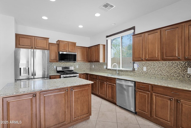 8710 N 182nd Ave, Waddell, AZ 85355 - kitchen with visible vents, a kitchen island, a sink, appliances with stainless steel finishes, and backsplash