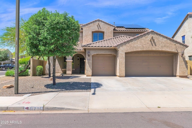 8710 N 182nd Ave, Waddell, AZ 85355 - mediterranean / spanish house featuring solar panels, a tile roof, a garage, concrete driveway, and stucco siding