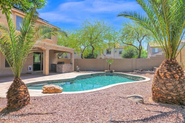 8710 N 182nd Ave, Waddell, AZ 85355 - view of pool featuring a fenced in pool, a fenced backyard, a patio area, and exterior kitchen