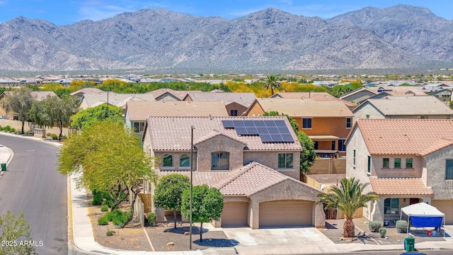 8710 N 182nd Ave, Waddell, AZ 85355 - view of front facade with a residential view, roof mounted solar panels, concrete driveway, an attached garage, and stucco siding