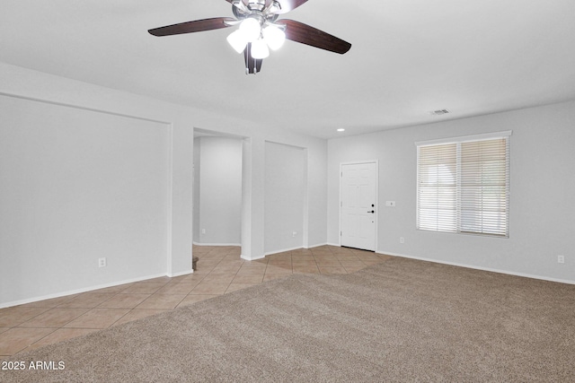8710 N 182nd Ave, Waddell, AZ 85355 - unfurnished living room with tile patterned floors, baseboards, a ceiling fan, and carpet floors
