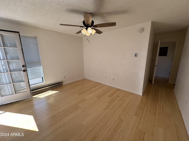 empty room with a textured ceiling, light wood-type flooring, ceiling fan, and a baseboard heating unit