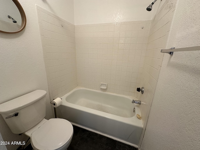 bathroom featuring tiled shower / bath combo and toilet