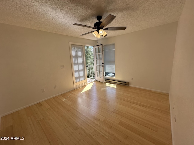 spare room with a textured ceiling, light wood-type flooring, a baseboard radiator, and ceiling fan