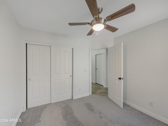 unfurnished bedroom featuring light colored carpet, ceiling fan, and a closet