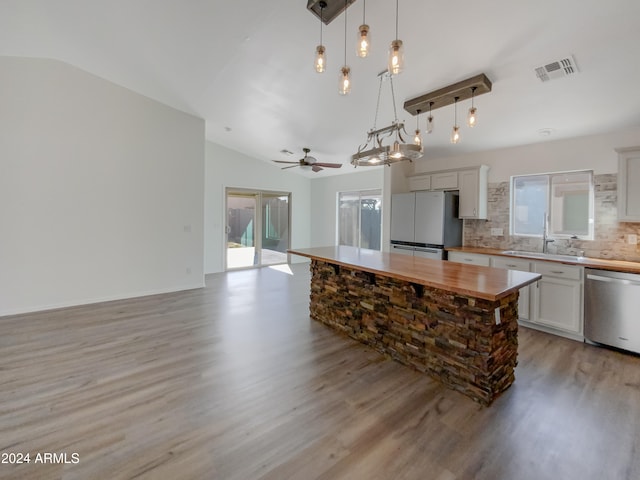 kitchen with white refrigerator, vaulted ceiling, dishwasher, butcher block countertops, and pendant lighting