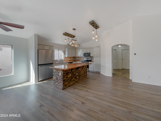 kitchen featuring stainless steel appliances, sink, hanging light fixtures, light hardwood / wood-style flooring, and a center island