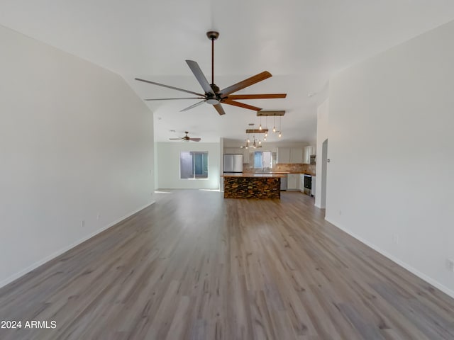 unfurnished living room with ceiling fan, light hardwood / wood-style flooring, and lofted ceiling