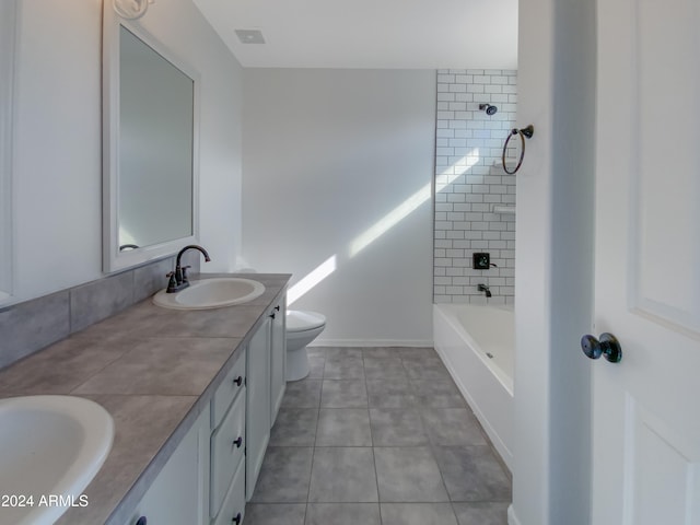 full bathroom featuring tile patterned flooring, vanity, tiled shower / bath combo, and toilet