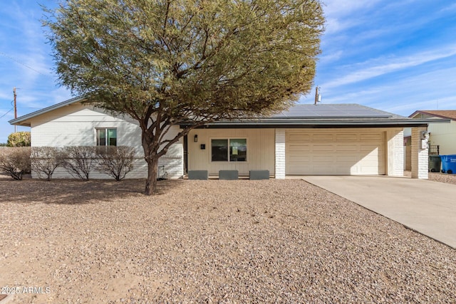 ranch-style home with a garage and solar panels