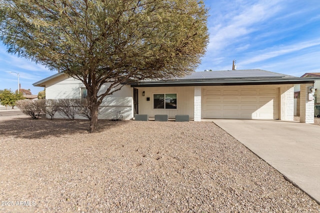 ranch-style home featuring a garage and solar panels