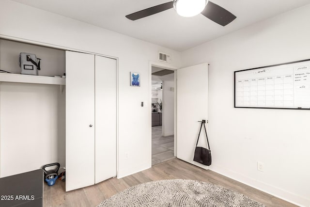 unfurnished bedroom with ceiling fan, a closet, and light wood-type flooring