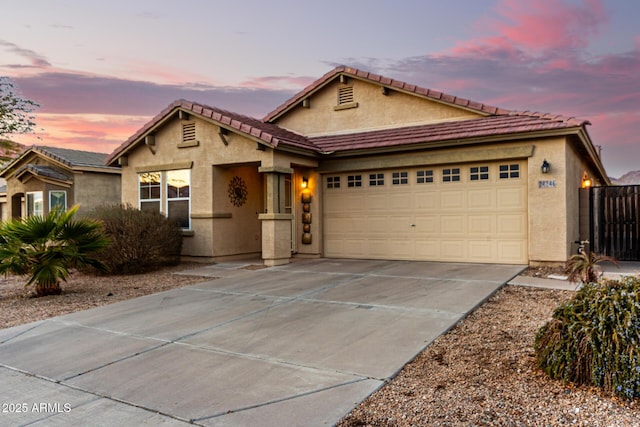 view of front of house with a garage, concrete driveway, and stucco siding