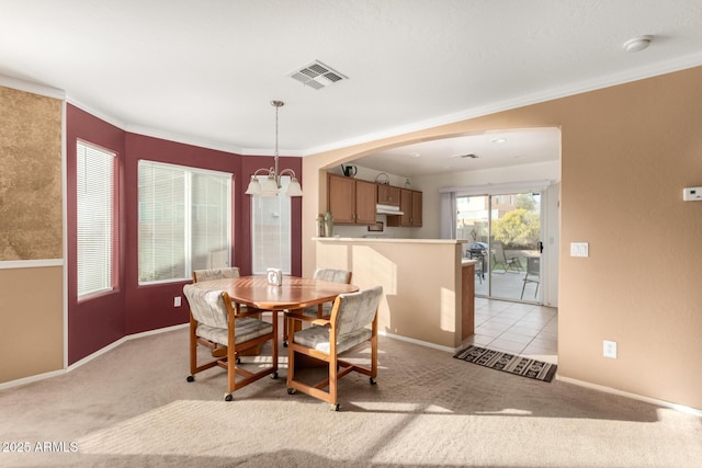 dining space with a chandelier, ornamental molding, light carpet, and visible vents