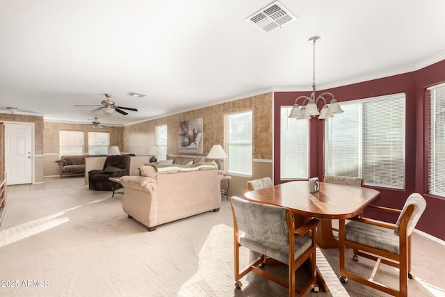 dining room featuring crown molding, a healthy amount of sunlight, visible vents, and light colored carpet