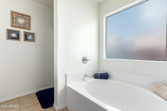 bathroom featuring baseboards, a bath, and tile patterned floors