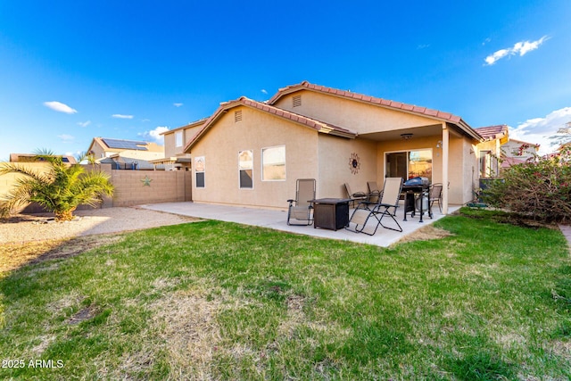 rear view of house with a fenced backyard, a patio, a lawn, and stucco siding