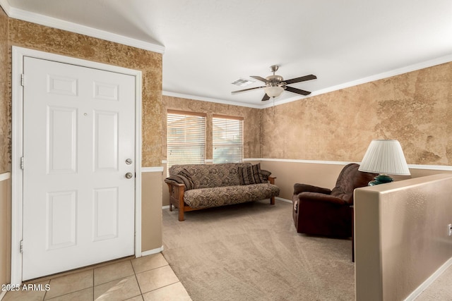 living area featuring carpet, crown molding, visible vents, a ceiling fan, and tile patterned floors