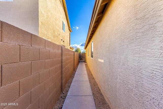 view of side of home featuring fence and stucco siding