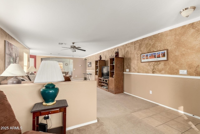 carpeted living room featuring baseboards, ceiling fan, visible vents, and crown molding