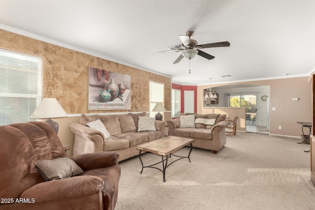 living area featuring a healthy amount of sunlight, light colored carpet, crown molding, and ceiling fan