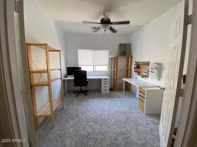 unfurnished office featuring carpet floors and ceiling fan