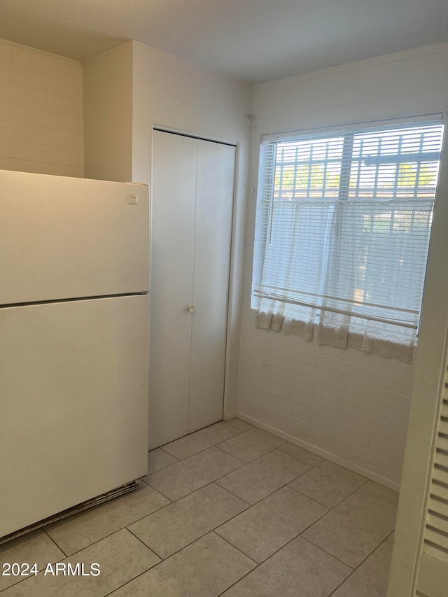 interior space with a closet, light tile patterned floors, and white refrigerator