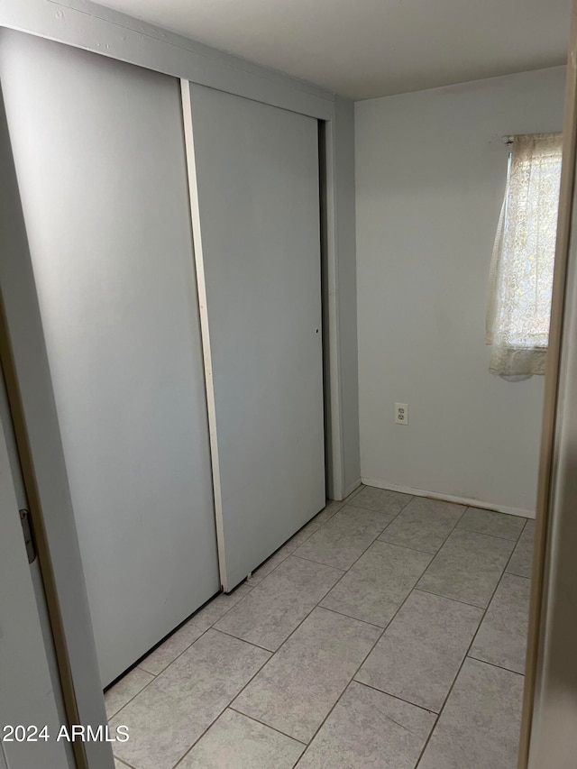 unfurnished bedroom with a closet and light tile patterned floors