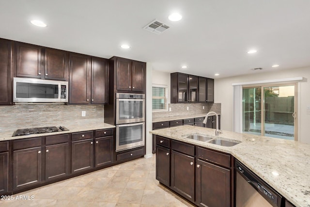 kitchen with visible vents, appliances with stainless steel finishes, light stone countertops, a sink, and recessed lighting