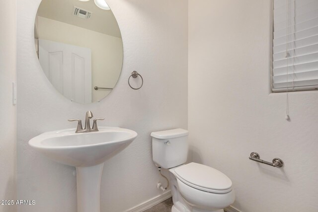 bathroom featuring baseboards, visible vents, and toilet