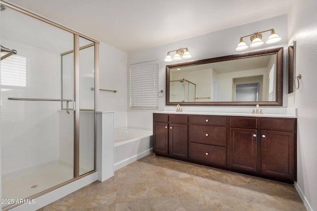 bathroom featuring double vanity, a garden tub, a shower stall, and a sink